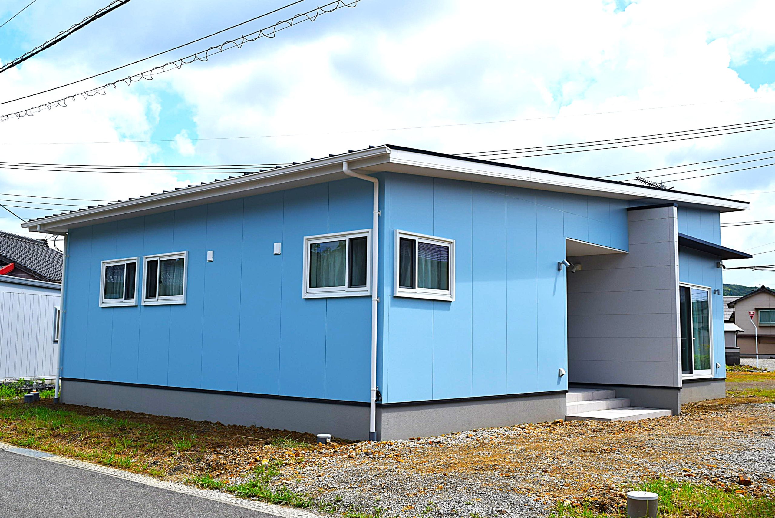 空と調和する、水色の外壁が映える爽やかなおウチ